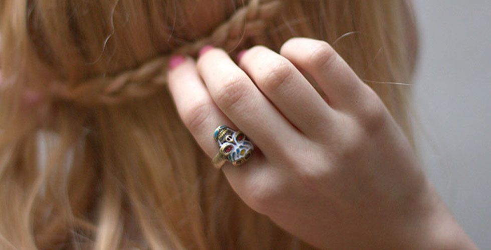 <p>O <a href="http://www.dicasdemulher.com.br/caveirismo-a-moda-das-caveiras-em-roupas-e-acessorios/">caveirismo</a> permanece no mundo dos acessórios por algum tempo. Para quem quer ousar aposte nos anéis duplos, já quem quer aderir à moda de maneira mais discreta, o anel de caveira colorida da foto pode ser uma excelente opção. </p>