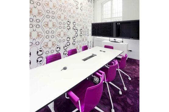 Escritório divertido tem poltronas coloridas na sala de reunião.