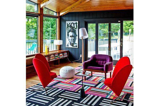 Cores vivas nas poltronas e tapete estampado dão vida ao ambiente.
