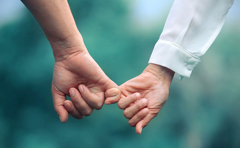 Casal de mãos dadas, simbolizando uma promessa