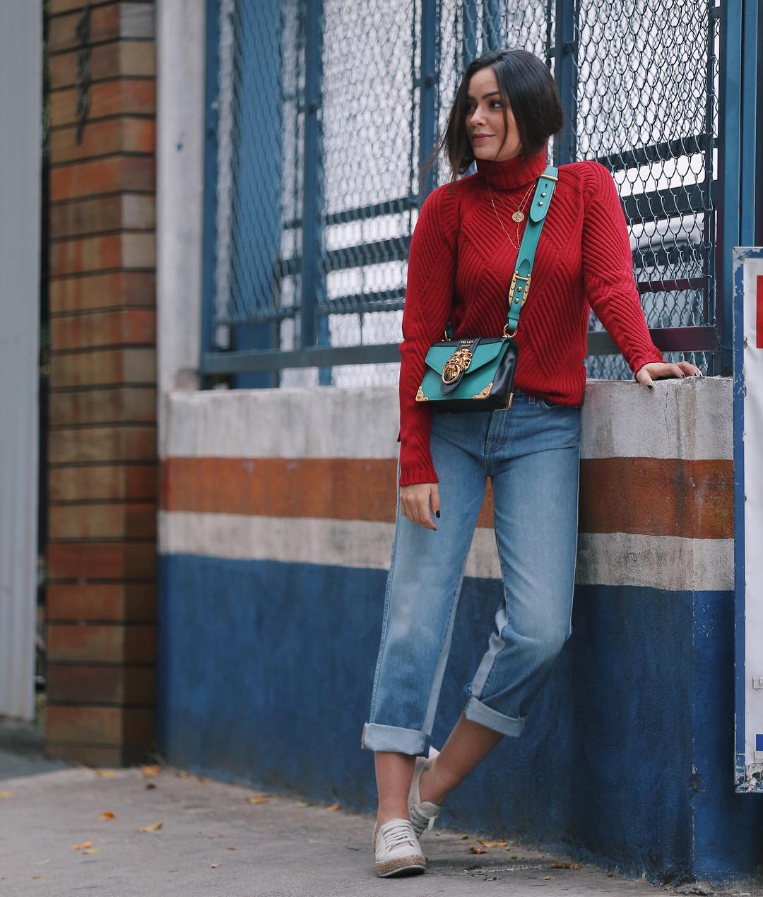 Look suéter vermelho, jeans com a barra dobrada e tênis branco