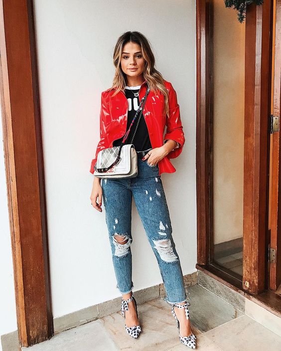 Look camiseta preta, jaqueta vinil vermelha, jeans e sparpin