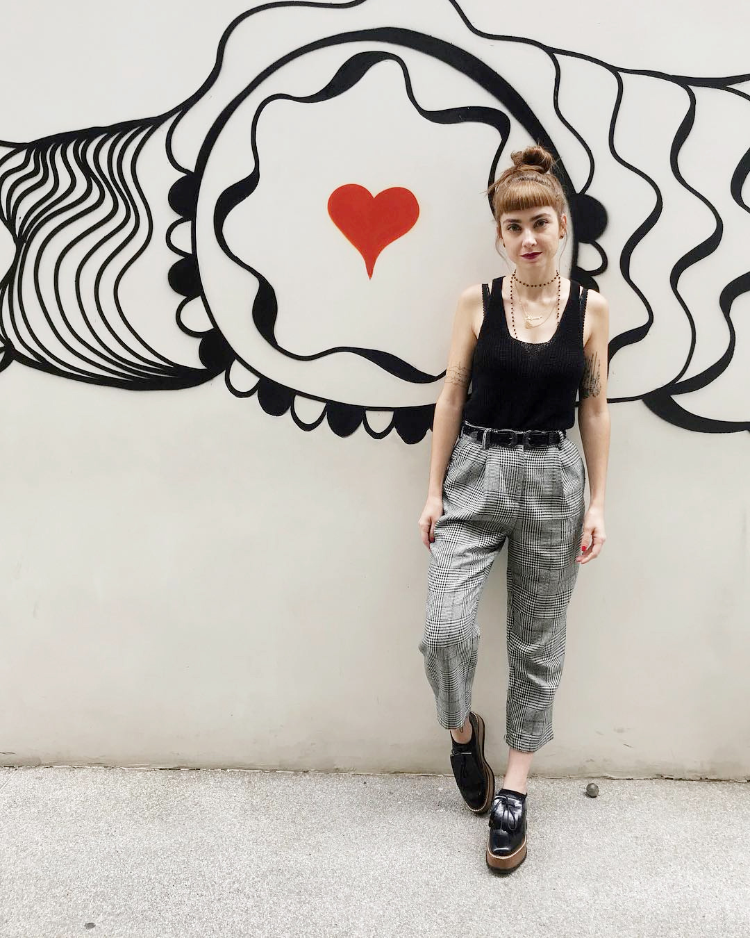 Look regata preta, calça alfaiataria xadrez e sapato masculino