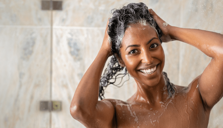 mulher lavando o cabelo com shampoo para crescer cabelo